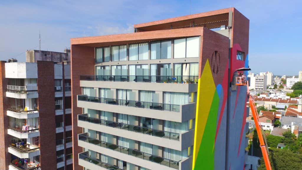 Un reconocido artista cordobés pinta un enorme mural sobre una pared del Hotel Mulen