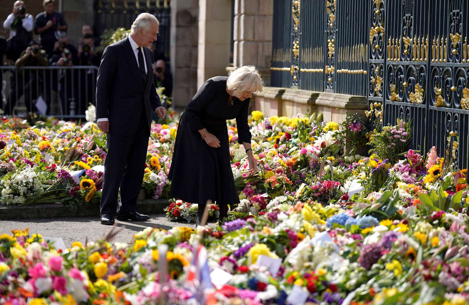 El rey Carlos III y la reina observan las ofrendas florales dejadas fuera del castillo de Hillsborough, en Irlanda del Norte