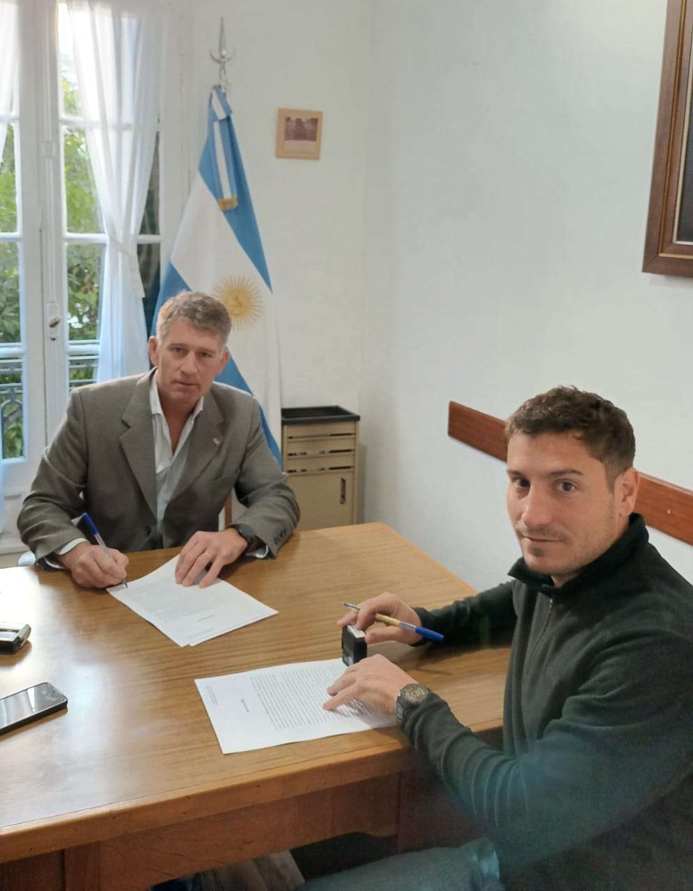 Fabián Riva firma un contrato con el proveedor Gerónimo Usandizaga.