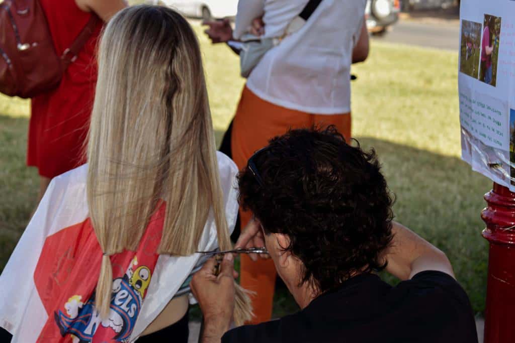En la plaza, los peluqueros trabajan de manera voluntaria para realizar pelucas que donan a pacientes oncológicos.