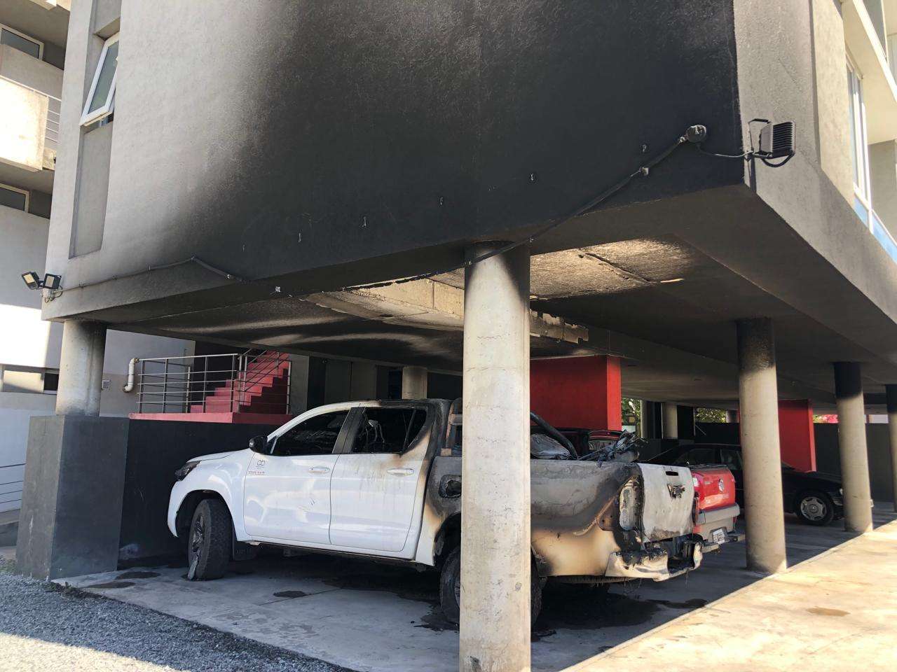 La camioneta, la moto y el complejo de departamentos afectados por las llamas.