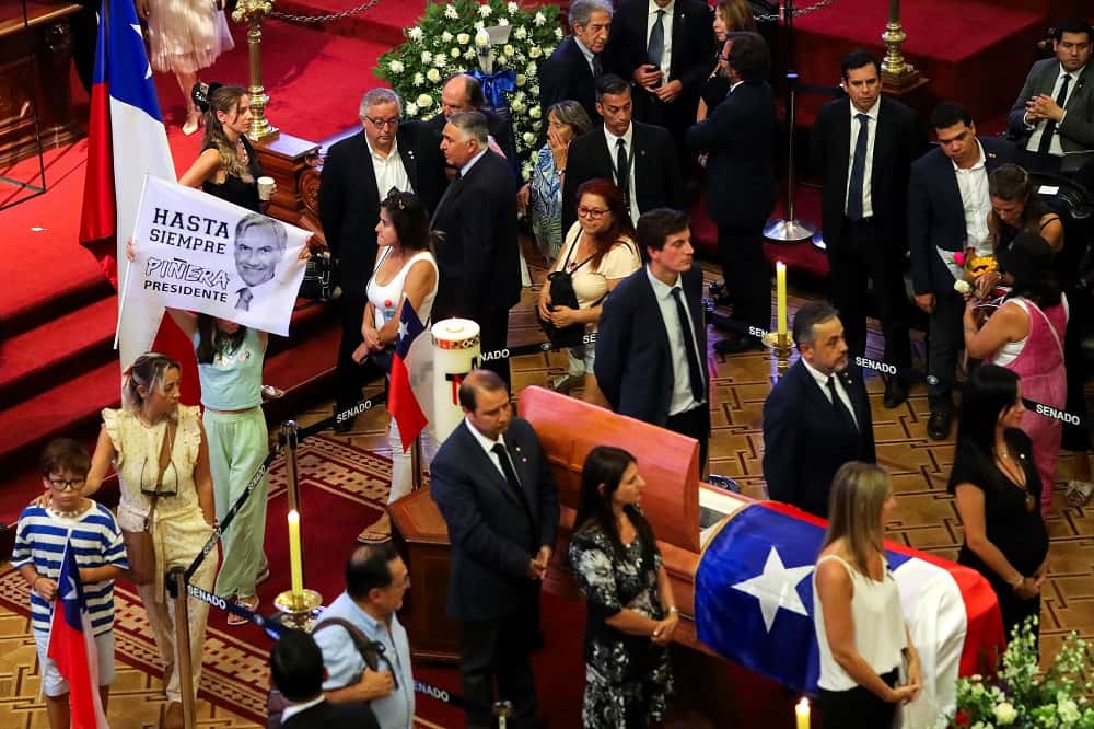 La gente presenta sus respetos mientras el féretro del expresidente Sebastián Piñera en el antiguo Congreso en Santiago.