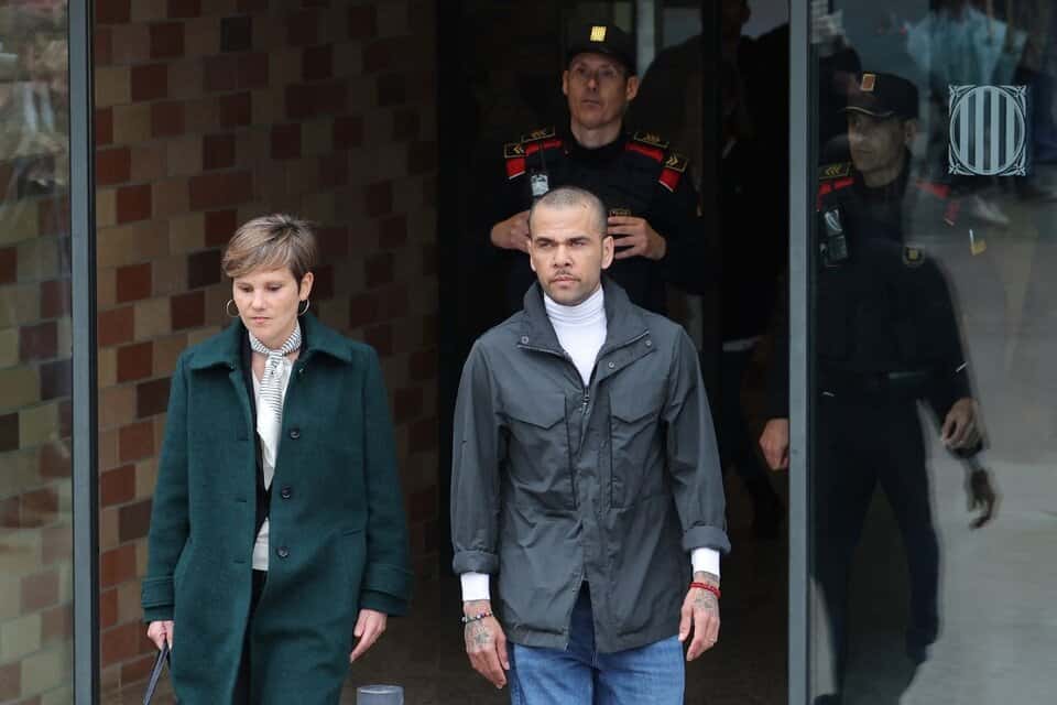Alves salió de prisión vestido con un suéter blanco, una campera gris y pantalones tejanos, con la vista al frente y la expresión de la cara seria.