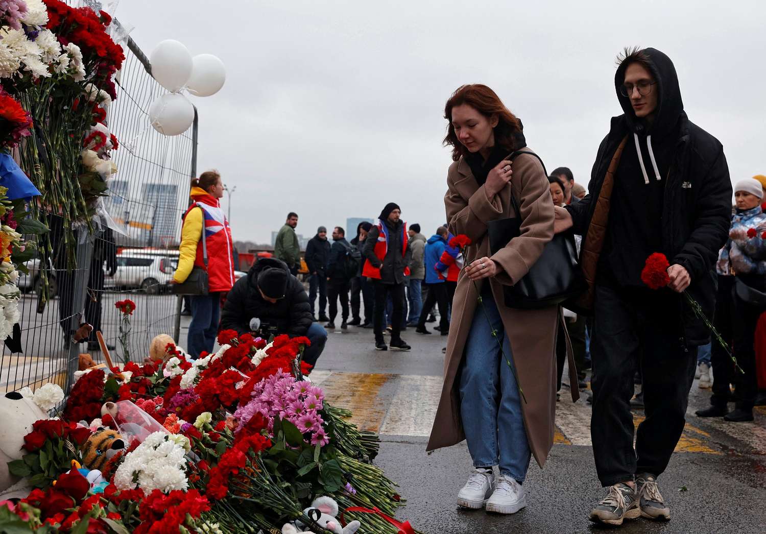 La gente deposita flores en un monumento improvisado a las víctimas de un ataque a tiros en la sala de conciertos Crocus City Hall.