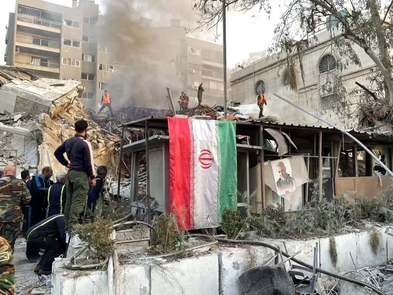 Una bandera iraní cuelga del edificio bombardeado en Siria.