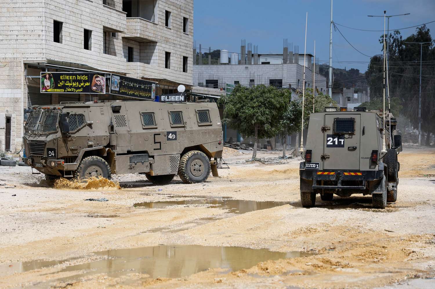Vehículos militares israelíes conducen durante una redada en un campamento.