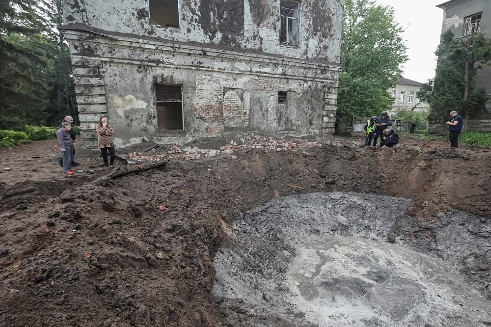 Expertos de la policía trabajan cerca de un cráter en los edificios del hospital dañados por un ataque con misiles rusos.